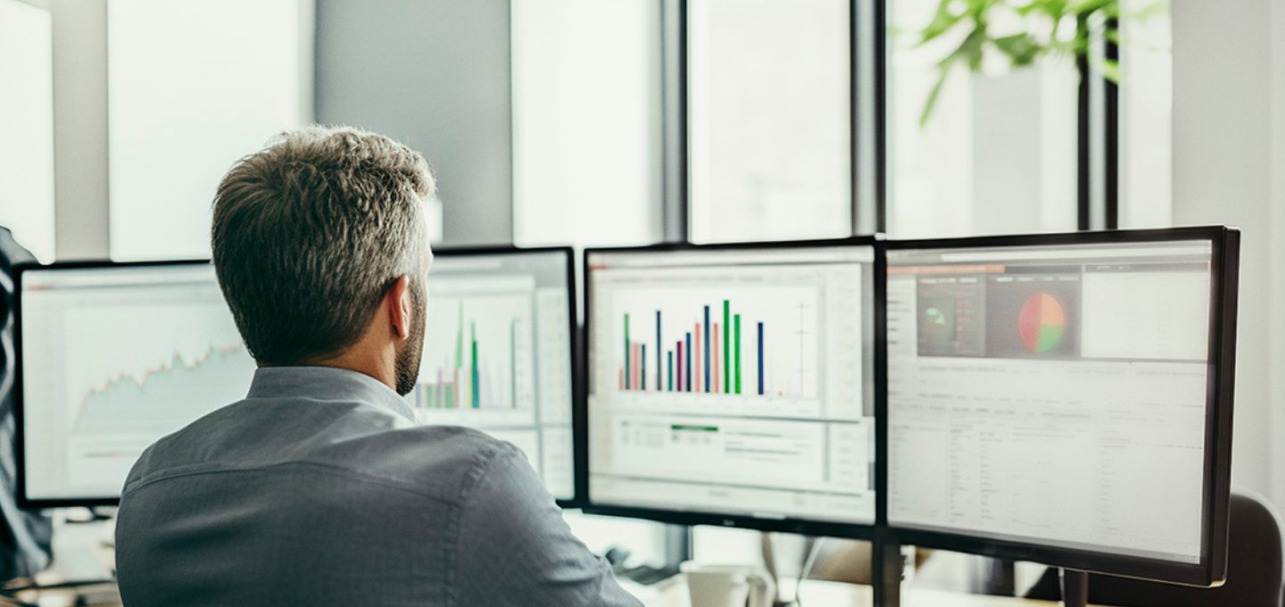 Man sitting in front of 3 monitor
